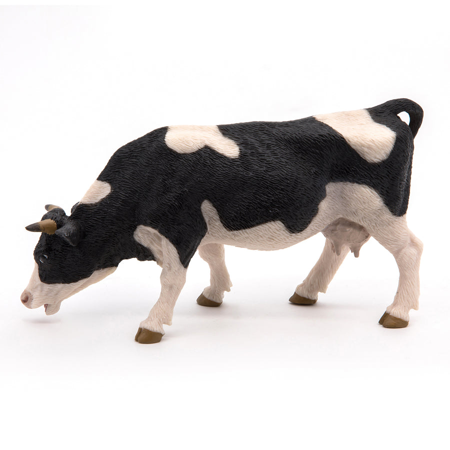 Black and white cow grazing figurine